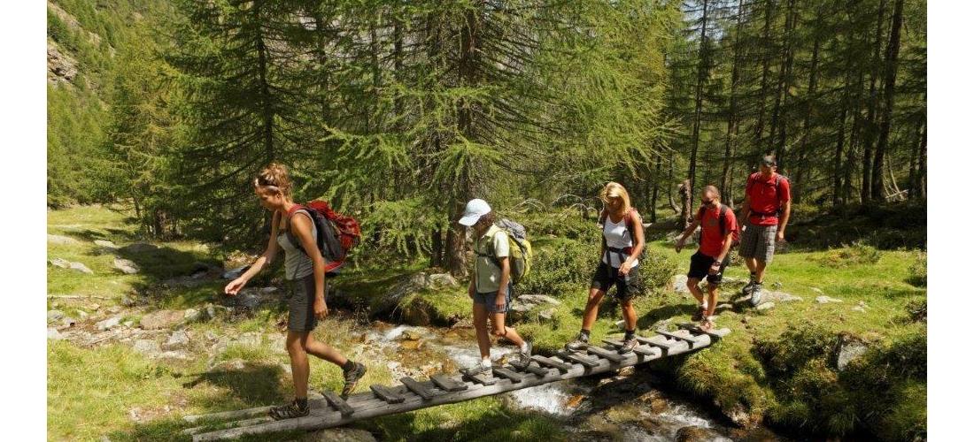 A group of hikers crosses a stream